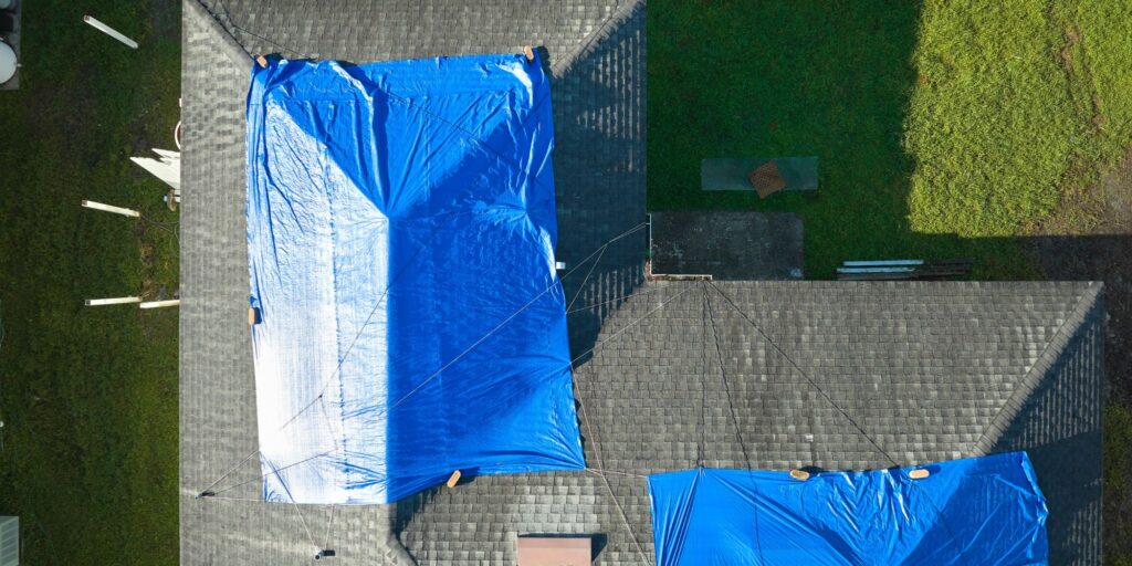 Emergency roof repair Wilmington crew tarping a damaged roof