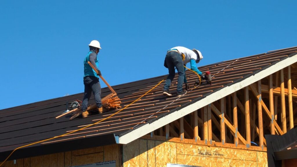 Roofing crew installing shingles on a home in Wilmington, NC — explore roofing careers with Breeze Roofing