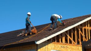 How long does a roof last in coastal NC - roofing crew installing shingles in Wilmington